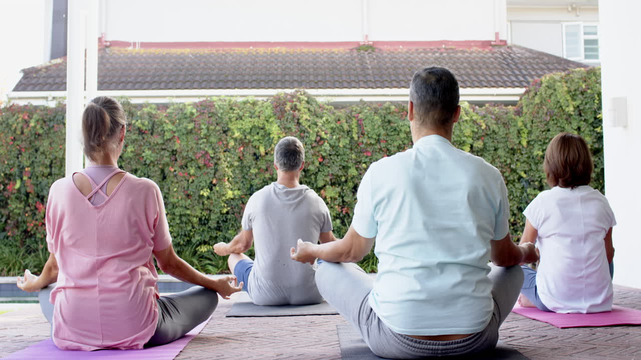 Practicing yoga, senior friends meditating on mats in outdoor session