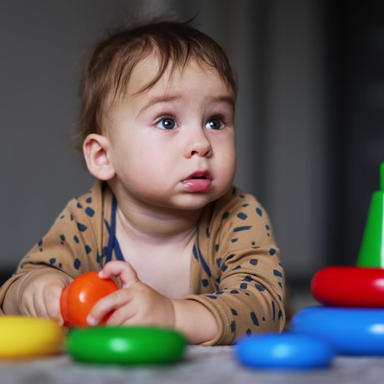 Small child playing with colored toys. Little cute boy in playroom