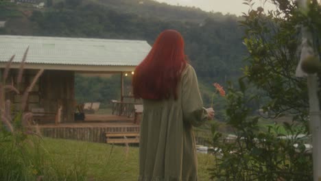 woman with red hair in a countryside garden