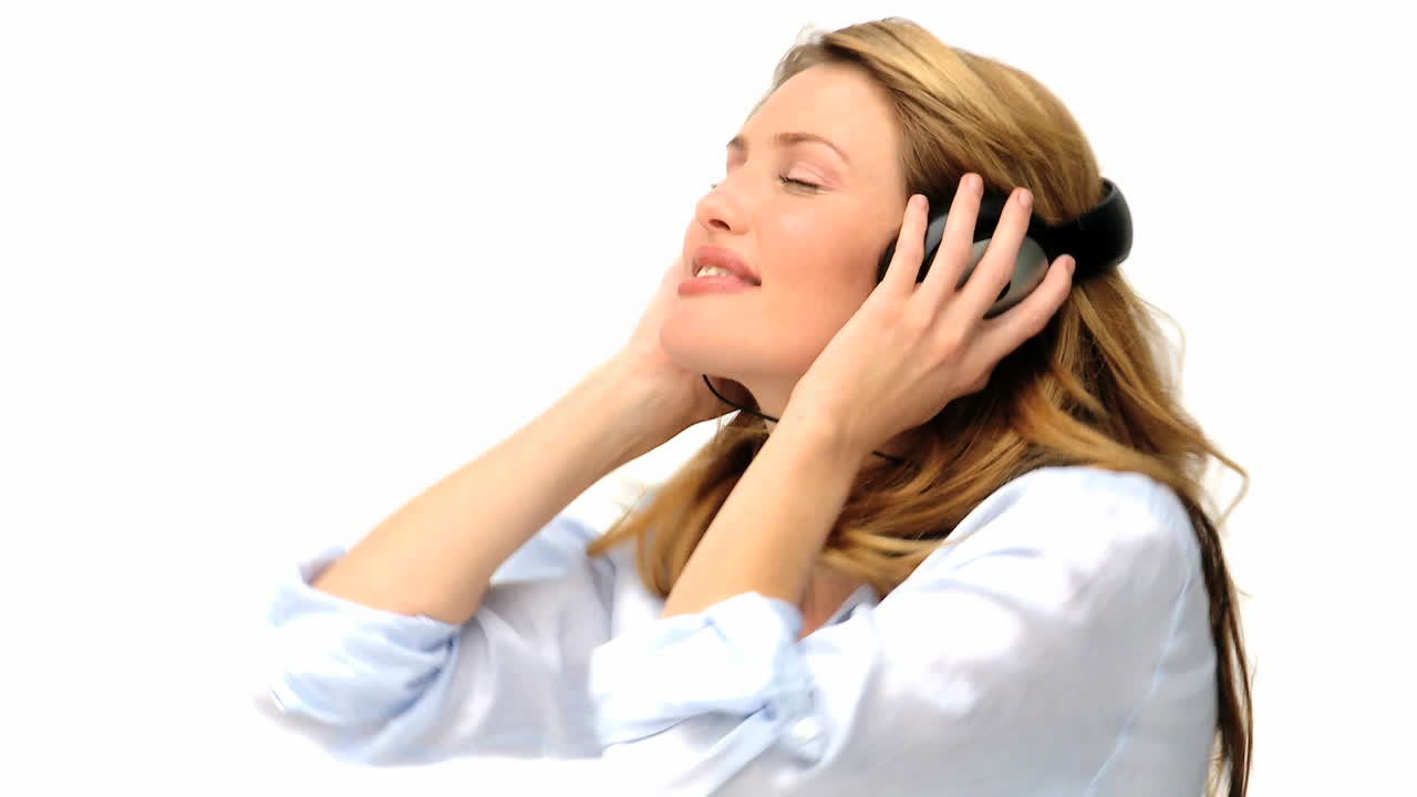 una linda mujer rubia bailando con auriculares.