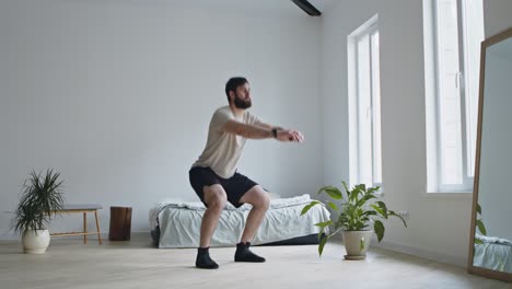 hombre haciendo sentadillas en casa