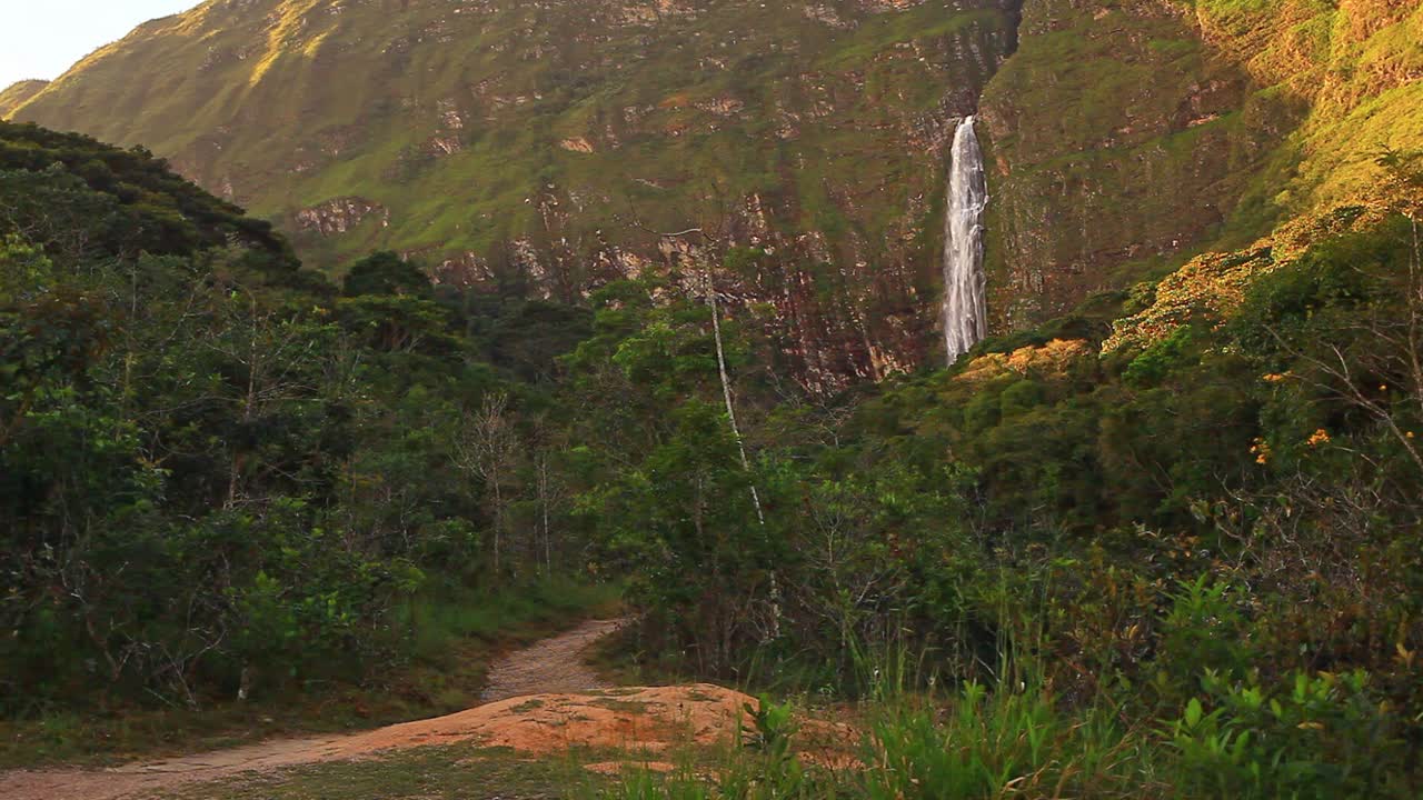 el comienzo del sendero que conduce a una pintoresca cascada tropical en la distancia