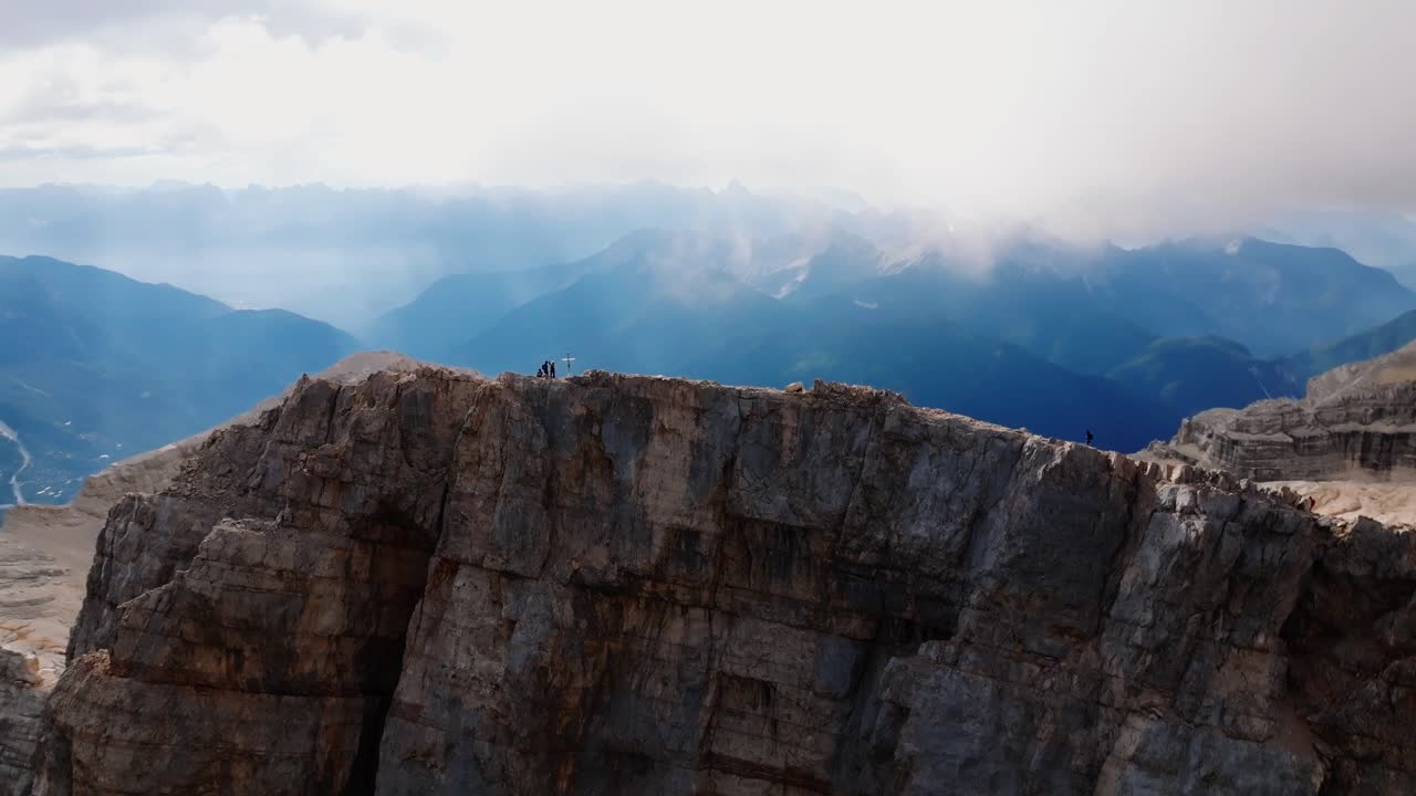 grupo de escaladores de roca activos que llegan a la cima de la montaña de monte pelmo durante un día soleado y nublado en italia - impresionante disparo en órbita de drones - grupo de excursionistas caminando por un camino extremo a lo largo del pico