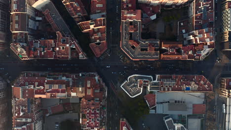 Overhead-Aufnahmen-Von-Fahrzeugen,-Die-Eine-Kreuzung-Passieren.-Straßen-Und-Gebäudeblöcke-Zur-Goldenen-Stunde.-Barcelona,-Spanien