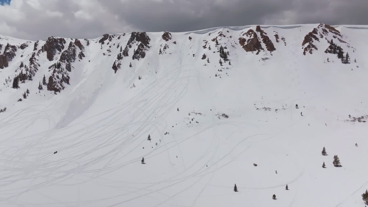 Montezuma Deer Creek winter spring deep backcountry powder snow aerial drone Colorado snowmobile tracks avalanche terrain cornice chute Rocky Mountain peaks sunny blue skies clouds snowmobile circle