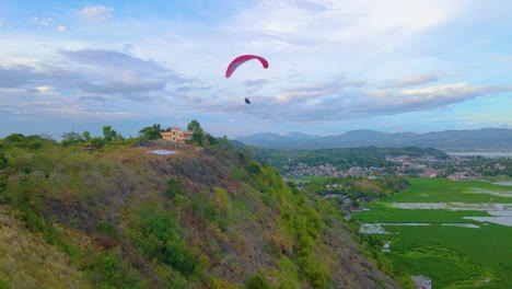 Paragliding-Across-Mountain-Ranges-Aerial-Drone-Push-In