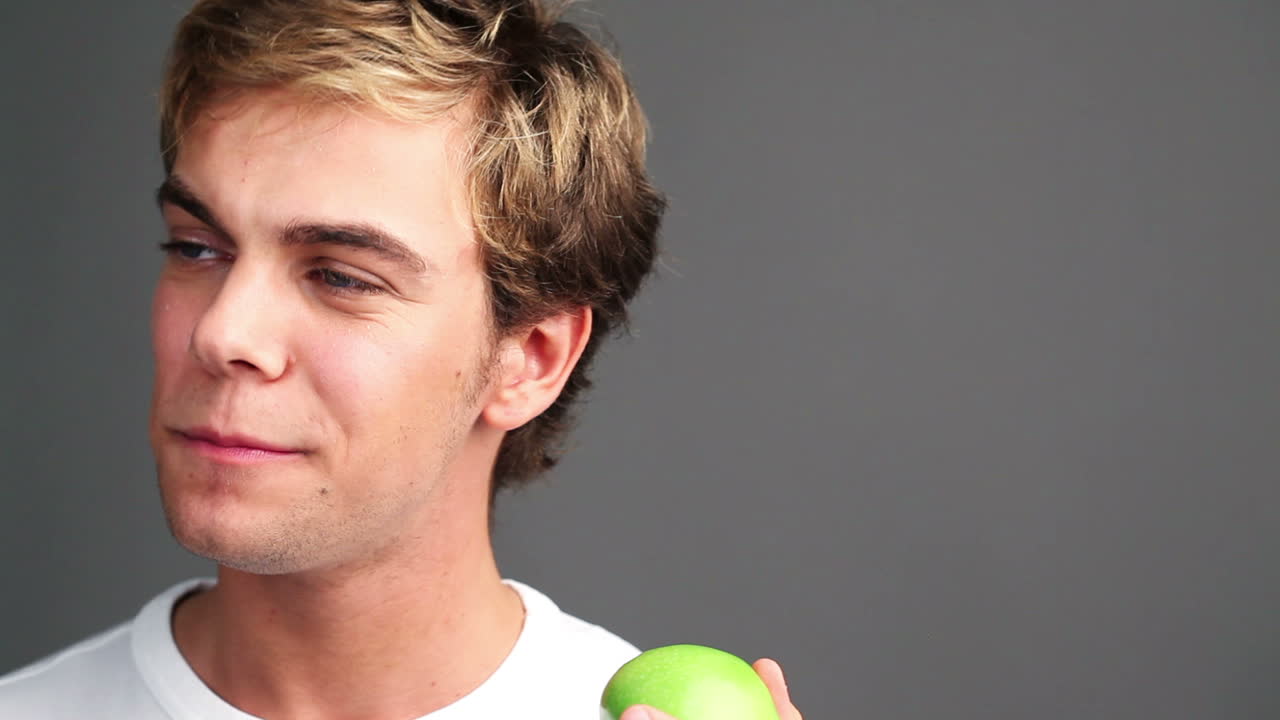 hombre sano comiendo manzana verde