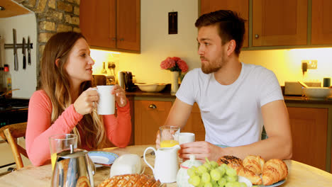 pareja tomando café en la mesa de comedor en la cocina 4k