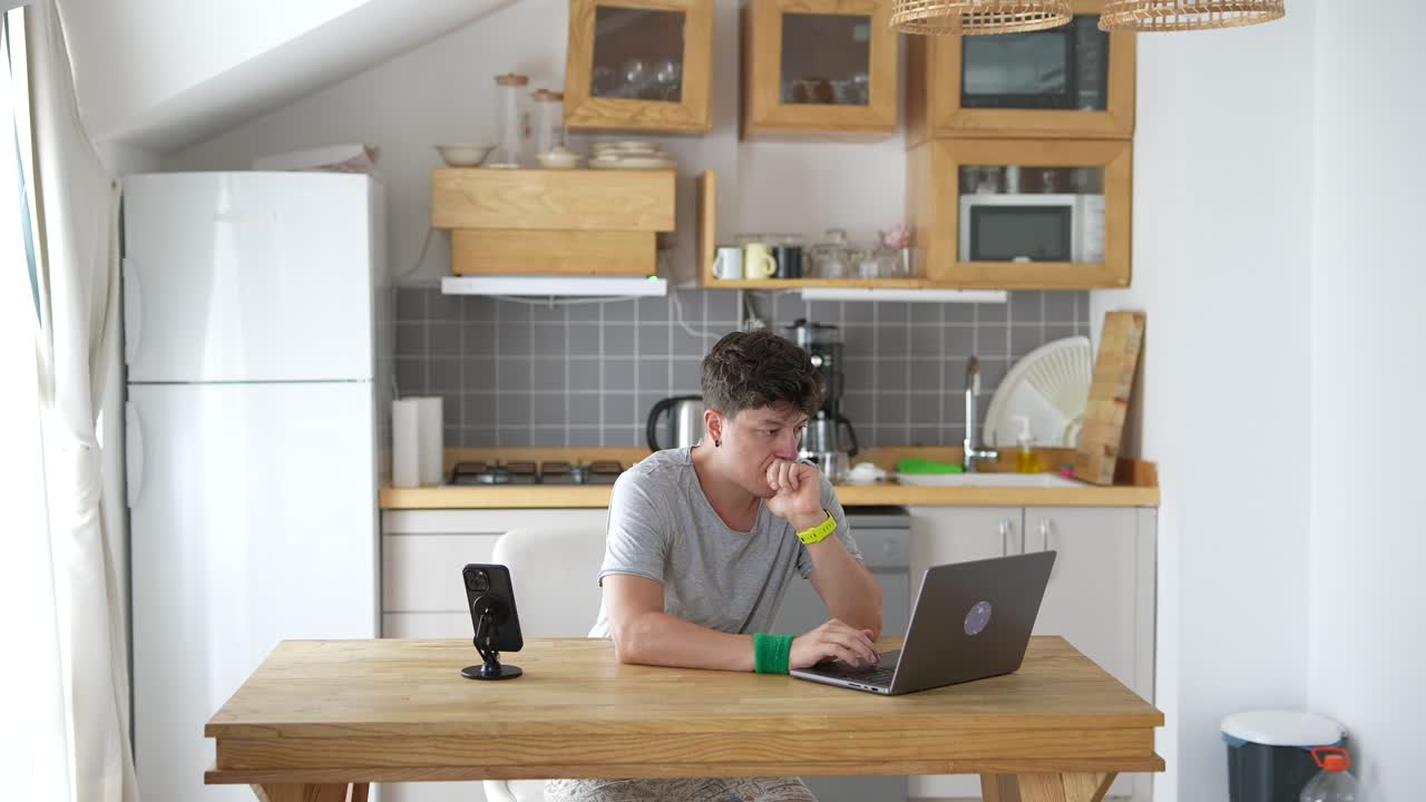 Person working on a laptop in a small kitchen