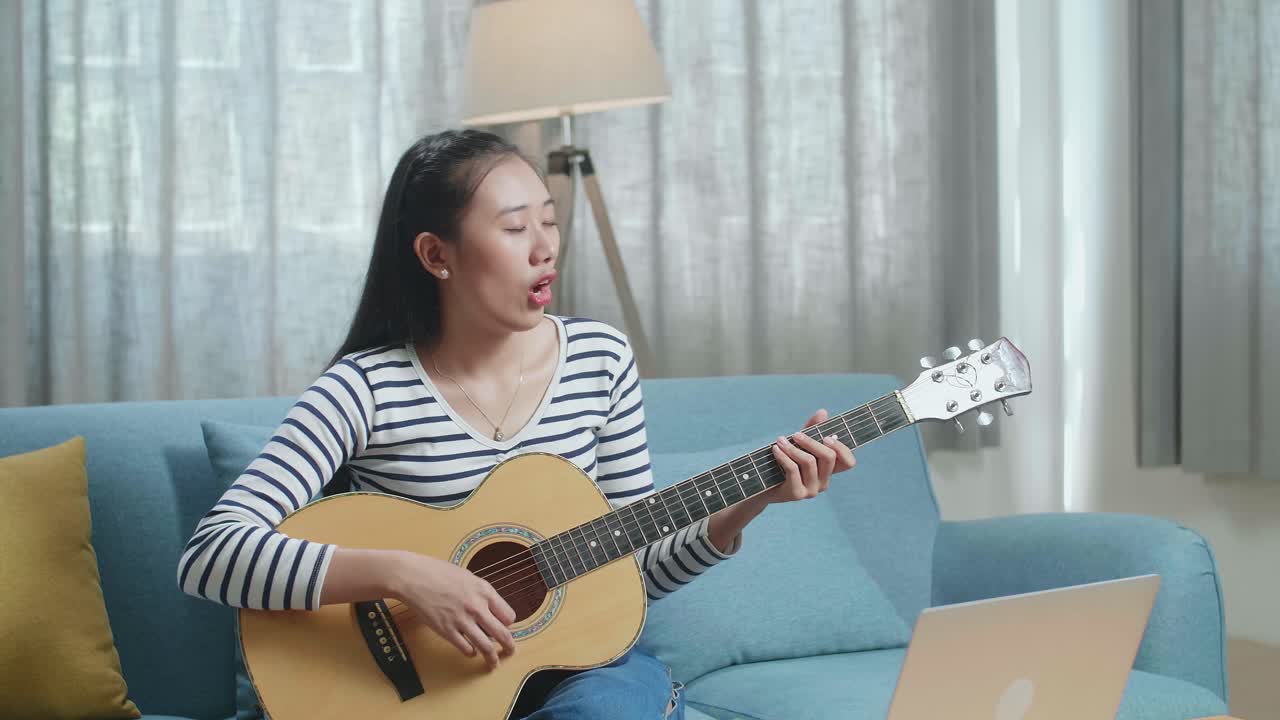 온라인에서 기타를 배우는 여자