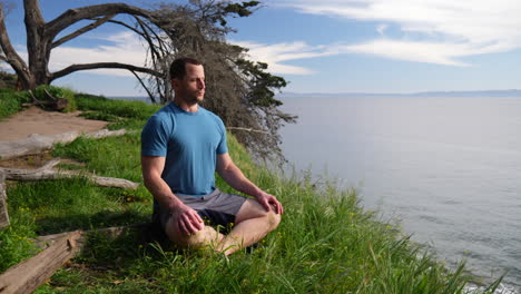 Ein-Fitter-Mann-Sitzt-In-Einer-Meditationspose-Und-übt-Tiefe-Atem--Und-Achtsamkeitsübungen-Auf-Einer-Strandklippe-Mit-Blick-Auf-Das-Meer-In-Santa-Barbara,-Kalifornien