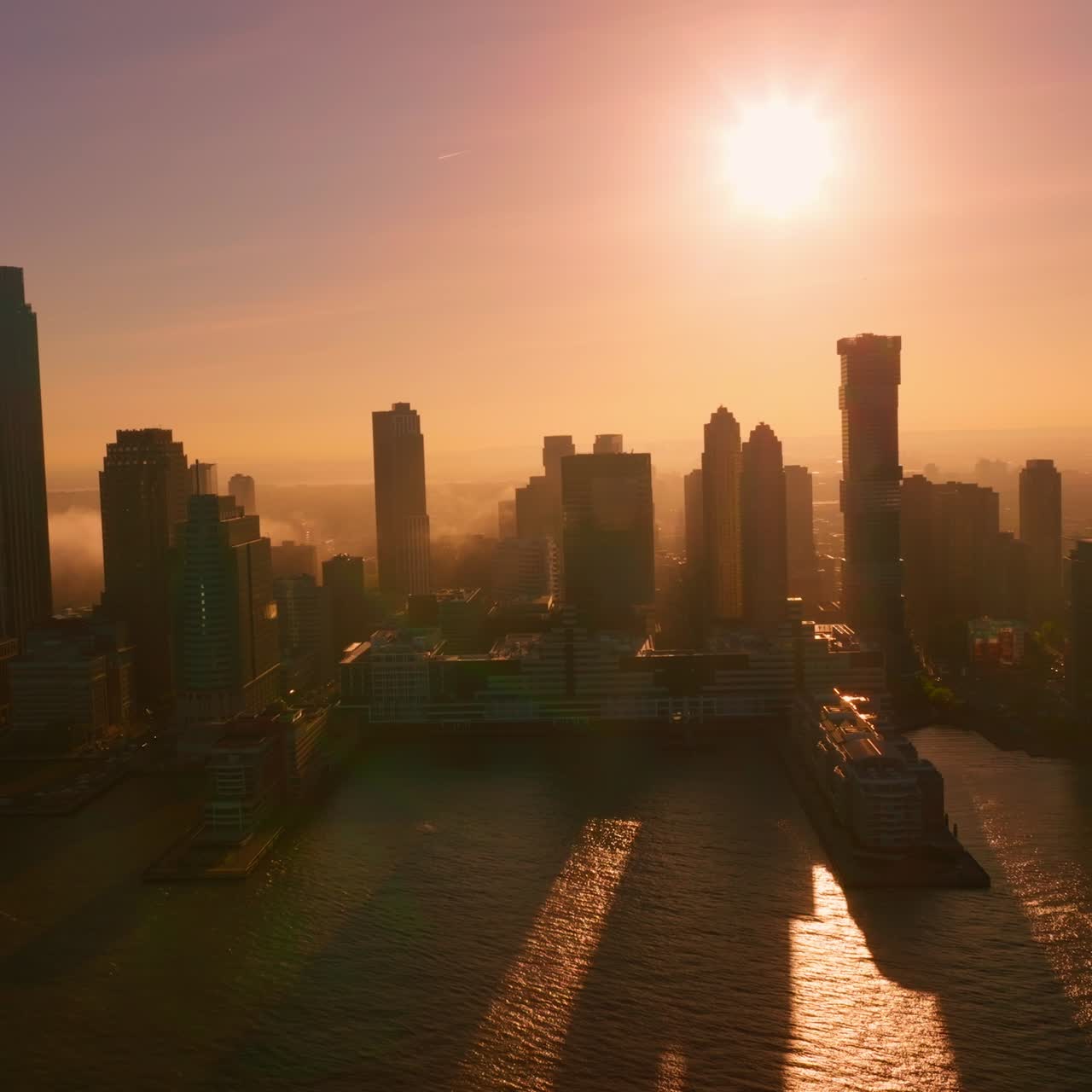 Silhuetas de edifícios incríveis na ilha de Manhattan. Arquitetura de Nova York na luz fraca do pôr do sol rosa