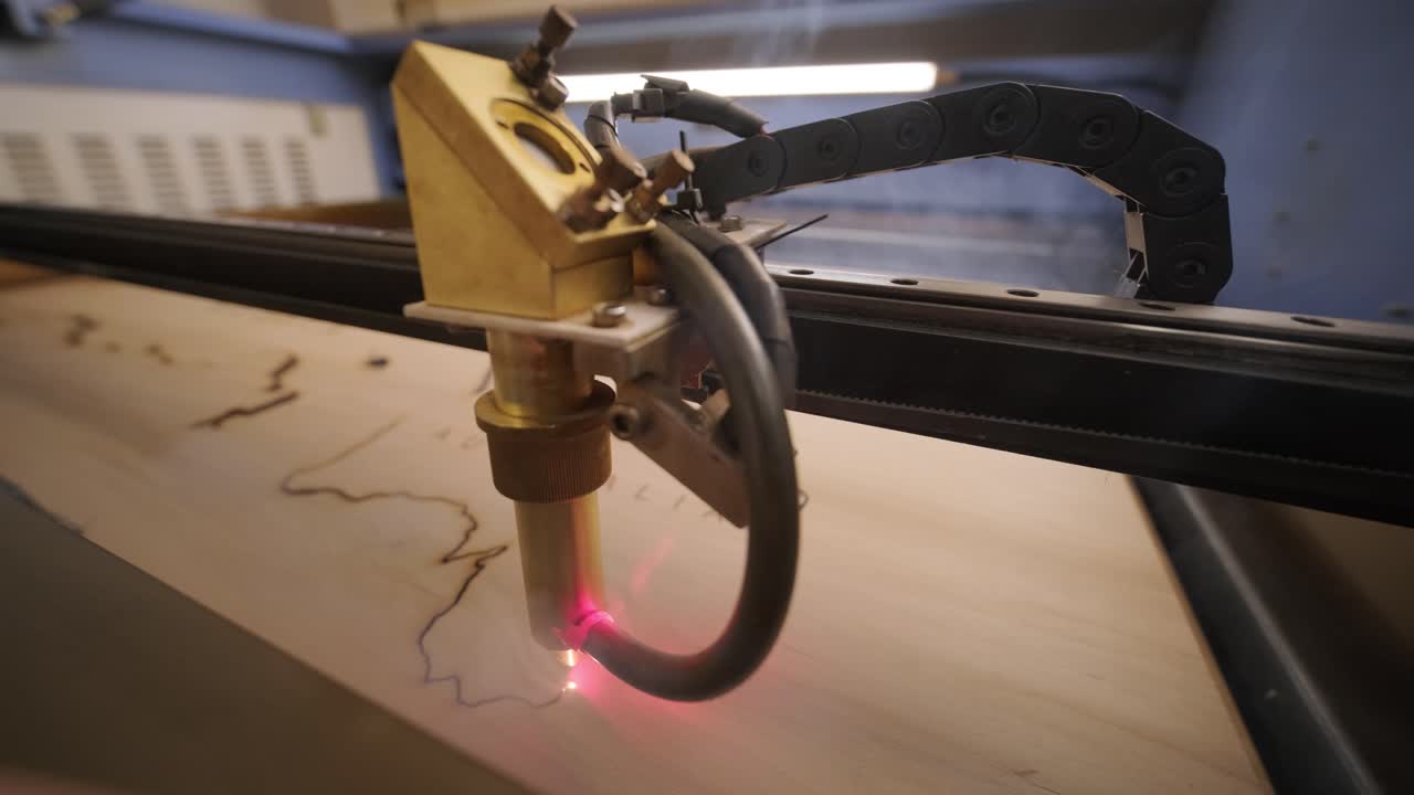 Macchina da taglio laser CNC taglia una mappa del mondo su tavola di legno e compensato