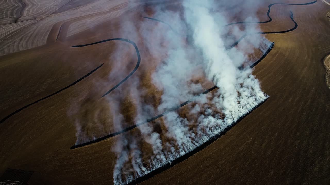 vista aérea de granjeros quemando terrazas con grandes nubes de humo