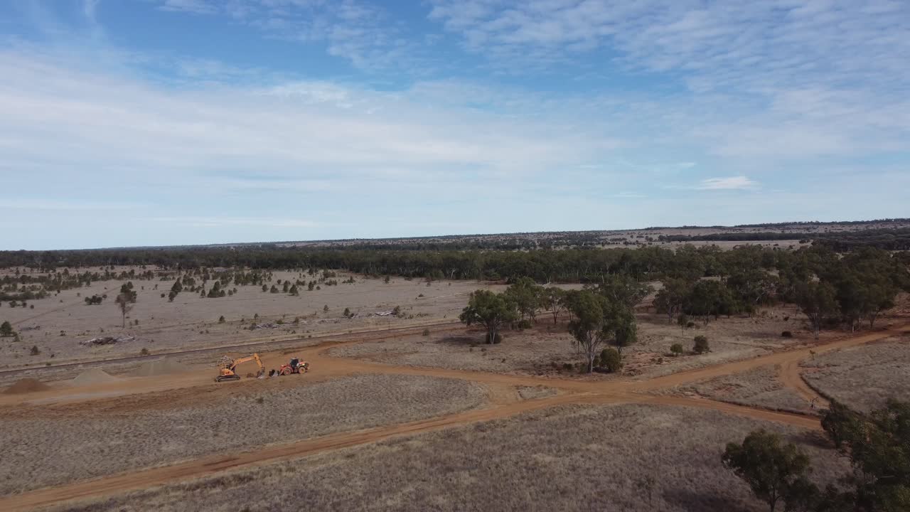 drone volando hacia maquinaria pesada en un paisaje de estilo desierto