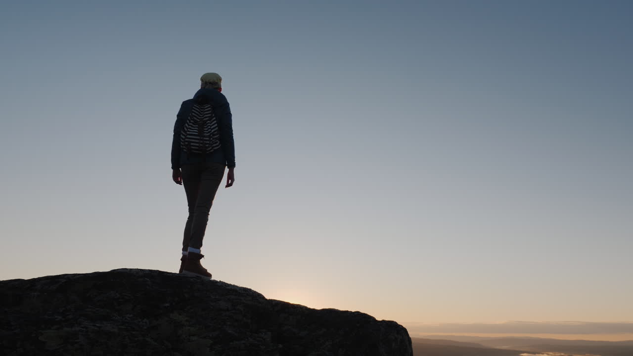 una mujer activa llega a la cima de la montaña con una vista impresionante abajo viajando en nor