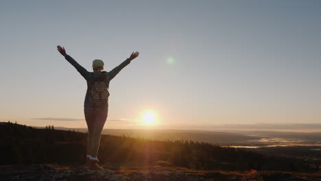 una mujer activa llega a la cima de la montaña con una vista impresionante abajo viajando en nor