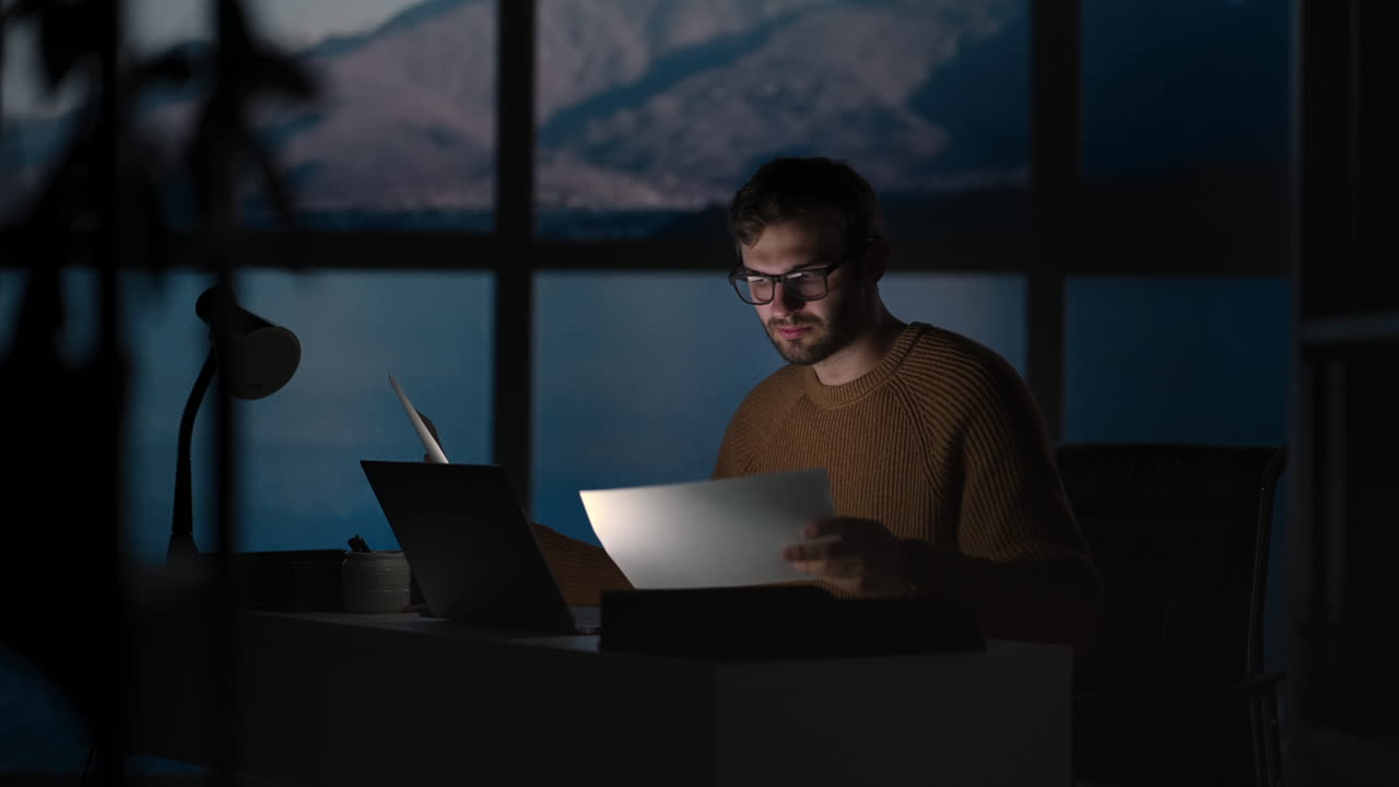 retrato de un hombre de negocios exitoso y reflexivo trabajando en una computadora portátil en su oficina de la gran ciudad por la noche. emprendedor digital carismático hace análisis de datos para la estrategia de comercio electrónico