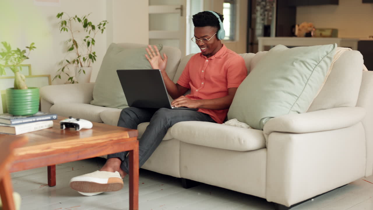 Black man wave during a video call on his laptop