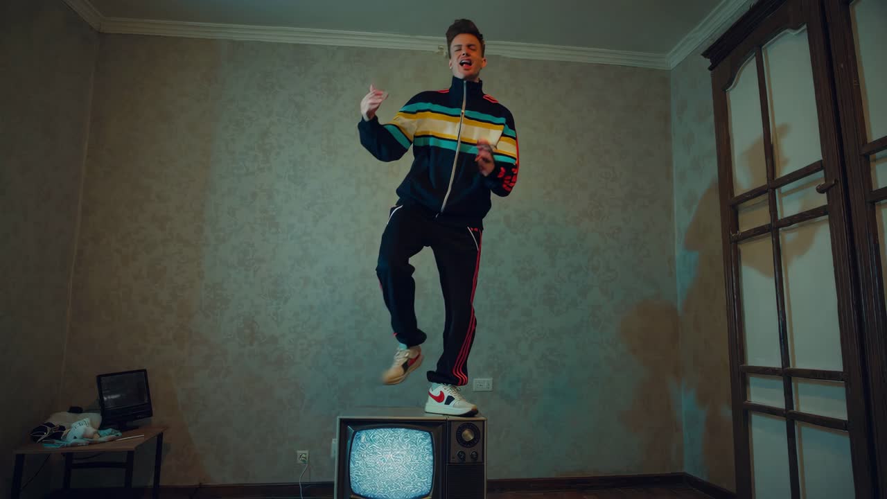 hombre en ropa deportiva retro en un televisor vintage