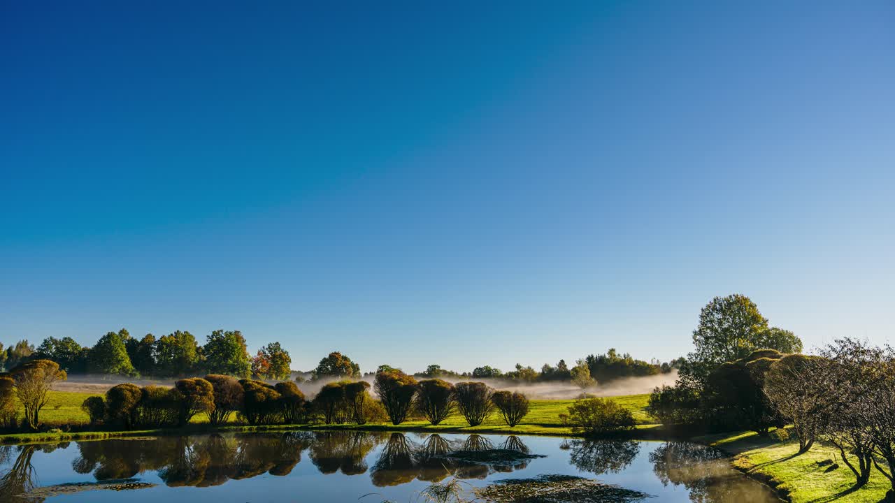 Early morning sunrise with fog clearing out over the landmark. Countryside sunrise timelapse. Rural area in Latvia.