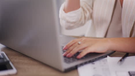 mujer de negocios escribiendo en la computadora portátil, primer plano en las manos