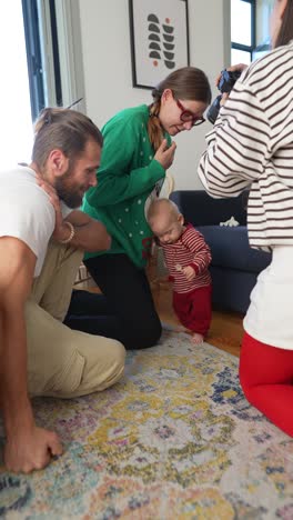 family watching baby take first steps