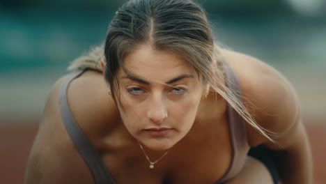 track runner looking up before race start in extreme slow motion, young female close up on windy day in 4k 800fps with hair blowing