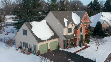 winter snow at traditional brick home decorated for christmas holidays