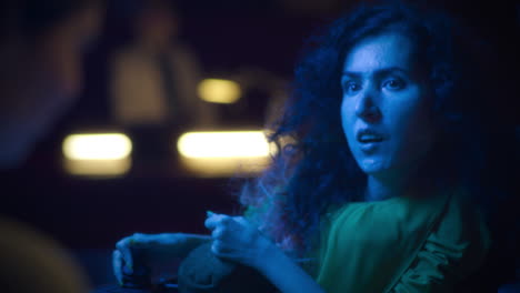 woman playing a video game in a dark room