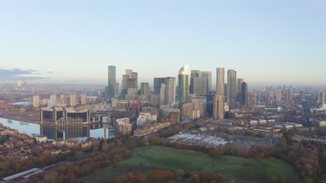 Lange-Filmische-Kreisende-Linke-Drohnenaufnahme-Von-Canary-Wharf-Wolkenkratzern-Aus-Dem-Süden-Bei-Sonnenaufgang