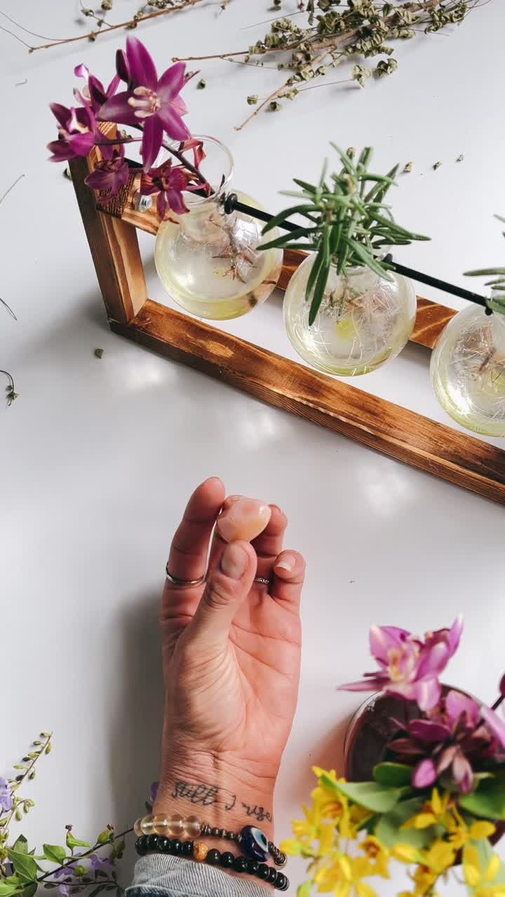 elegante arreglo floral con vasos de vidrio únicos y una mano