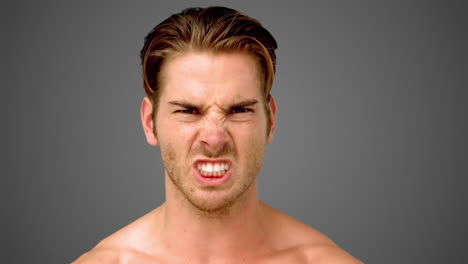 young man showing his anger on grey background