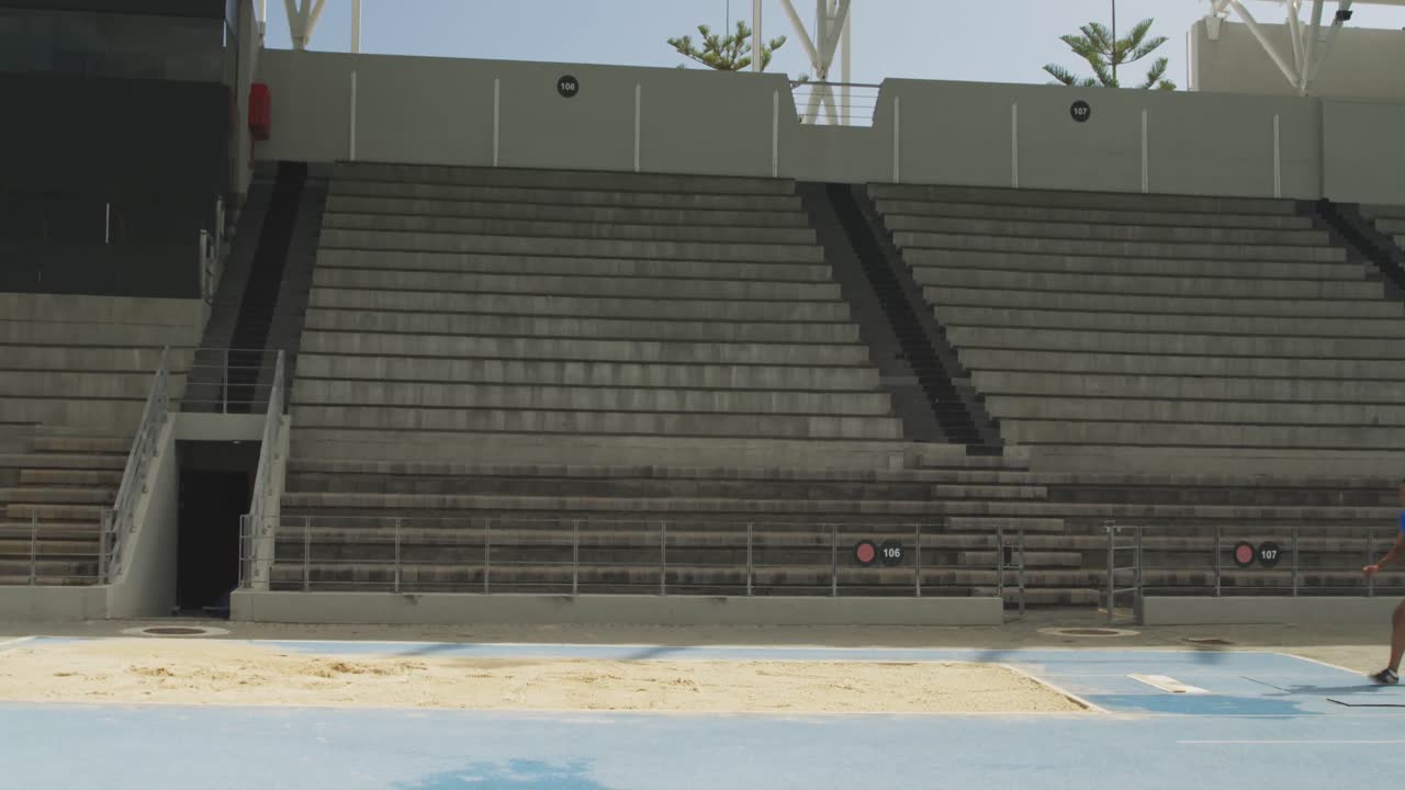 vista lateral de un atleta de raza mixta haciendo un salto de longitud