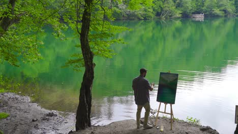 The painter paints among the trees.