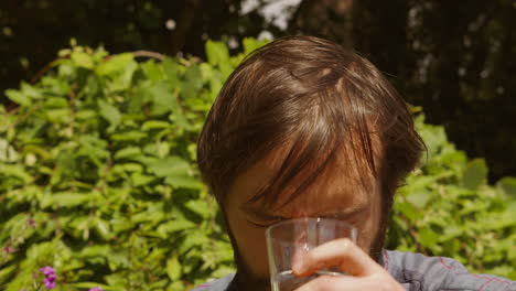 man drinking glass of water then pouring it on his head to stay cool in heatwave sun - slow motion