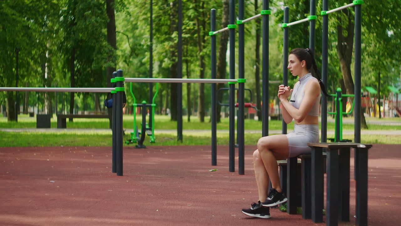 atleta femenina realiza estocadas laterales trabajar sus piernas y saltar en el parque en cámara lenta. mujer hermosa jugando deportes en el parque.