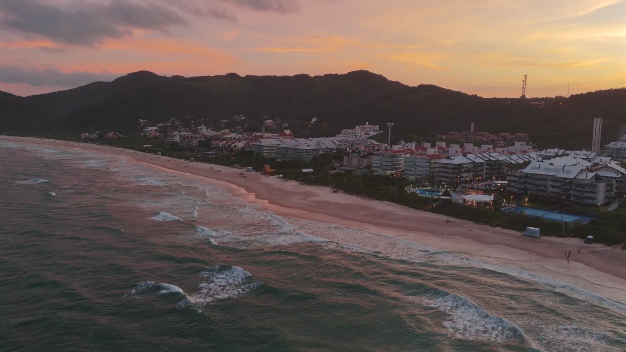 el atardecer sobre praia brava, florianópolis, mostrando sus lujosos condominios contra el telón de fondo del cielo colorido