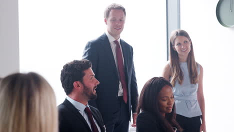 slow motion shot of young businessman speaking at meeting around boardroom table