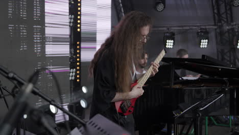 concert performance by musician with long hair