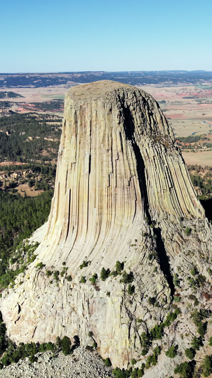 Vista aerea con drone del Monumento Nazionale Devils Tower che si erge imponente sopra il paesaggio circostante in Wyoming, USA. Verticale.