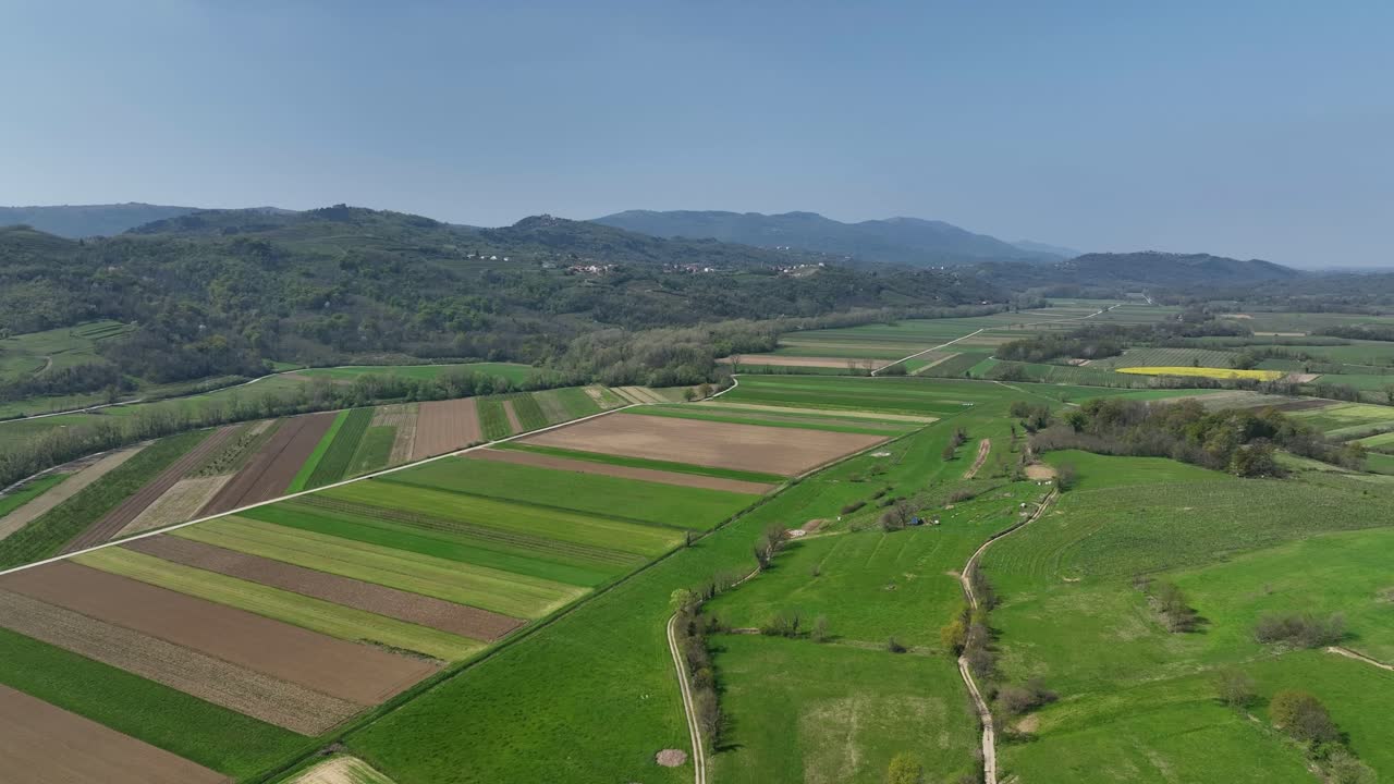 Lush landscape of Vipava Valley, with colorful patchwork fields and distant mountains