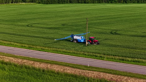 tractor spraying pesticides standing in the field. aerial