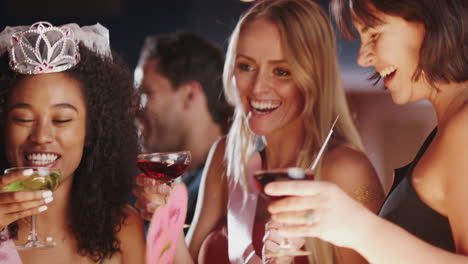 grupo de amigas celebrando con la novia en una fiesta de soltera en un bar