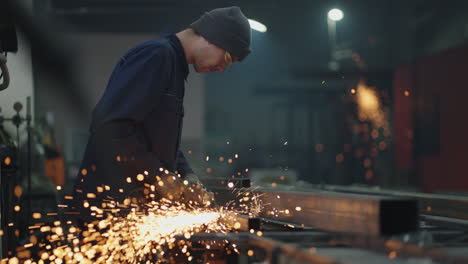 a factory worker grinds the metal after welding. production room worker grinding metal sparks fly in slow motion