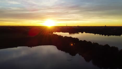 Horizon-of-Mechels-Broek-at-sunset-with-silhouetted-trees-around-reflecting-waters