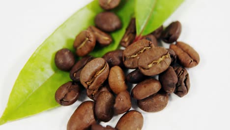 Close-up-of-roasted-coffee-beans-with-coffee-leaves