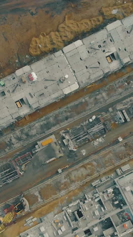 abandoned industrial zone with incomplete buildings and tremendous constructional cranes bird eye view
