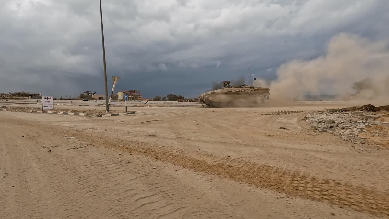 Un APC Namer con mitragliatrice calibro .30 montata solleva una nuvola di polvere nel deserto di Gaza