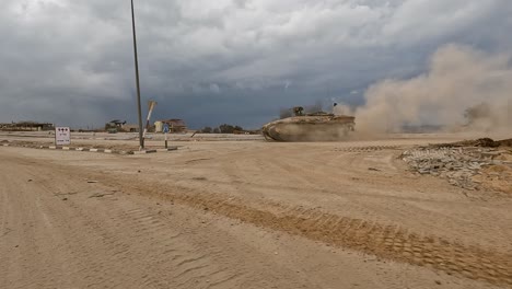 a namer apc with 30 cal mounted machine gun creates a dust cloud in gaza desert